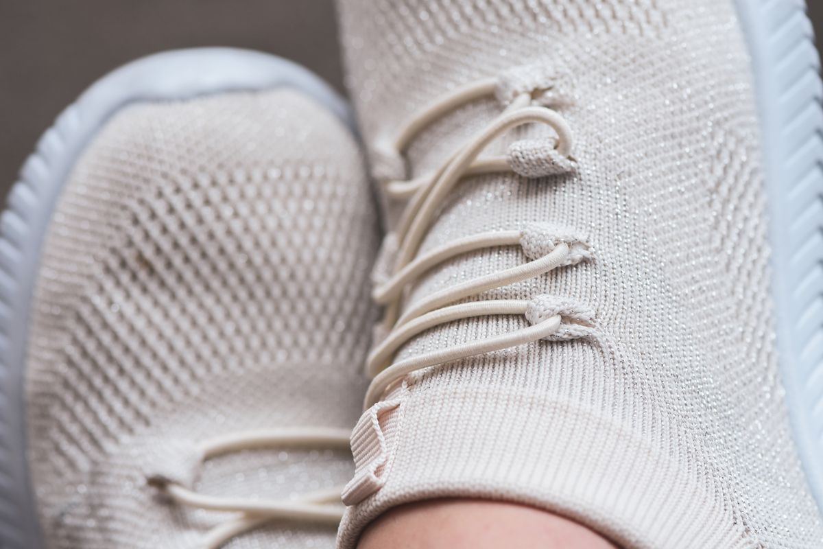 Close-up of light knit runner sneakers worn on feet