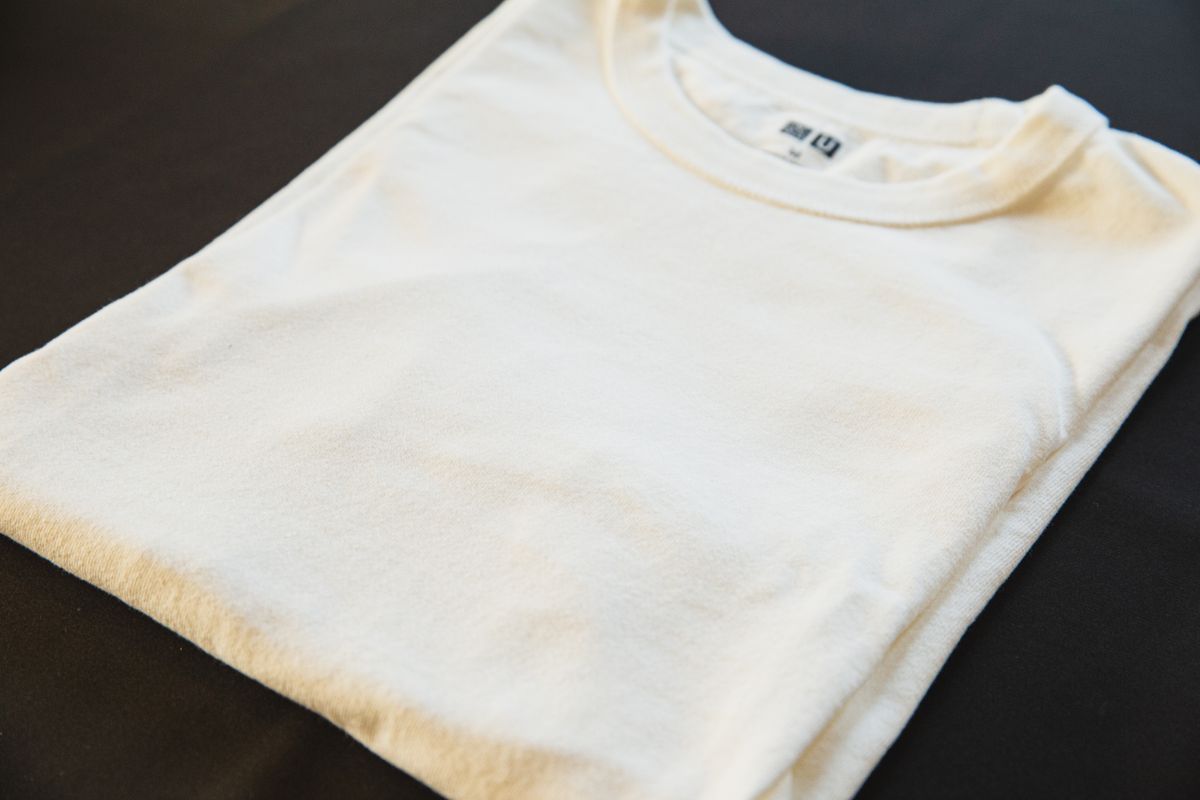 A folded white T-shirt on a dark background