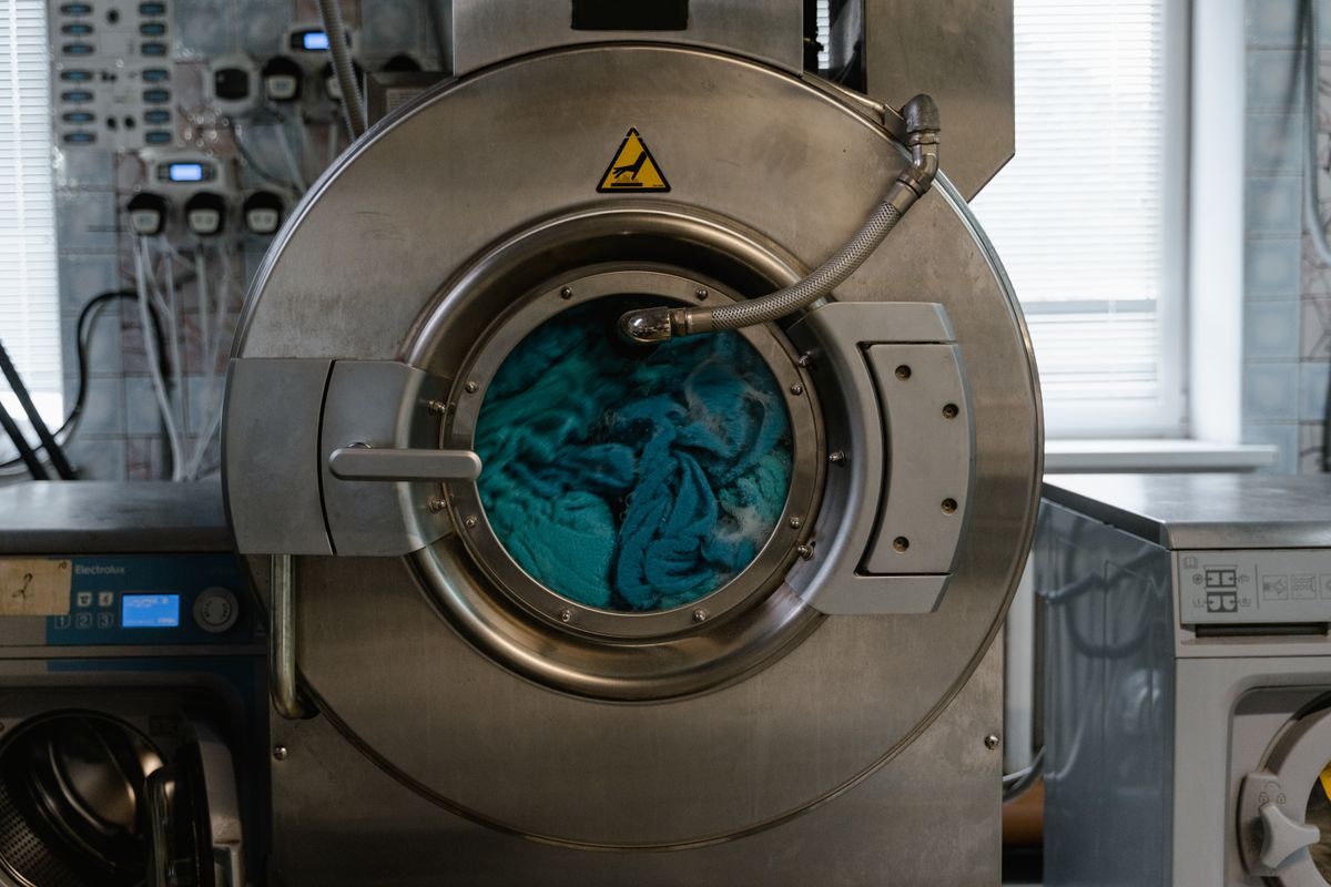 A home washing machine with its drain hose and lint trap visible