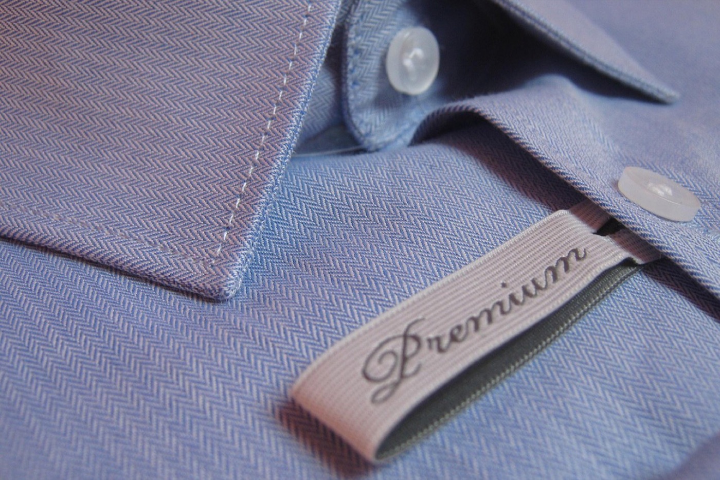 Woven clothing care labels and certification tags laid flat on fabric