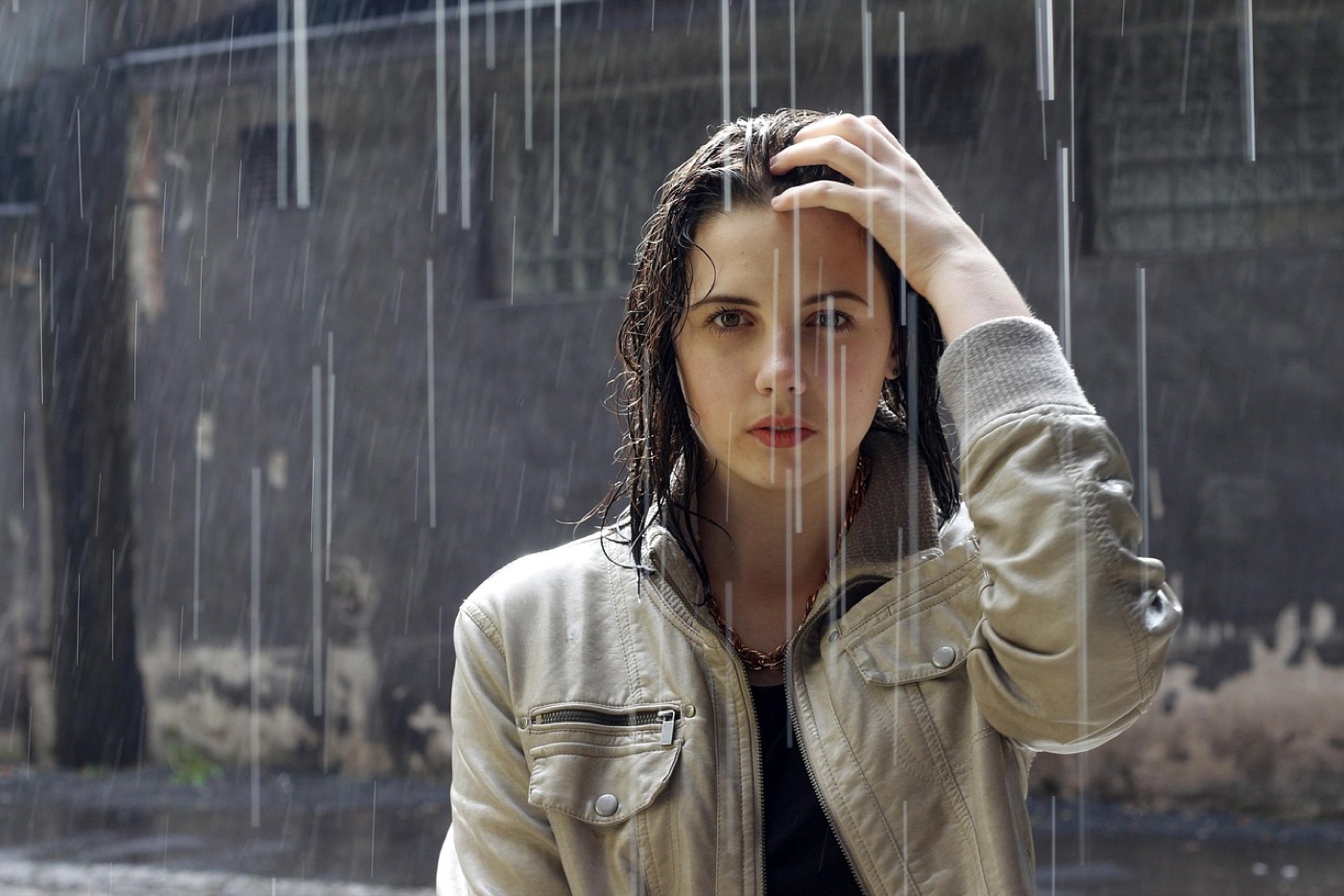 Person in a rain jacket standing under steady rainfall